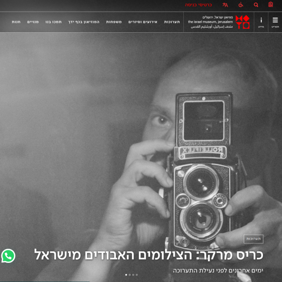 Person holding a vintage camera, reflected in a mirror, with Hebrew text overlay.